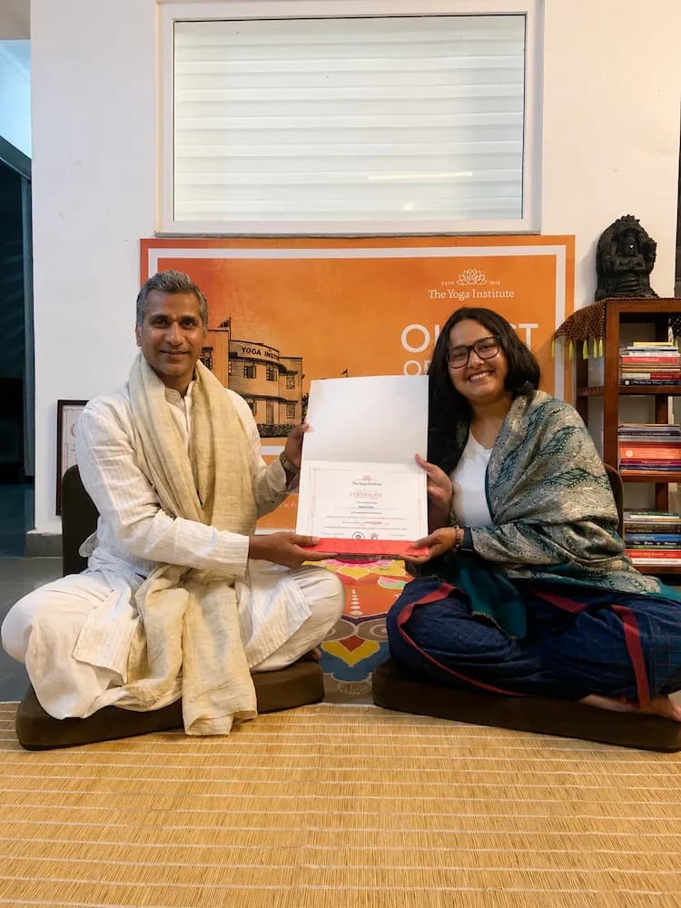 Simran receiving her yoga training certificate from her teacher
